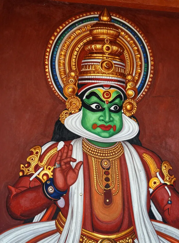 A Kathakali performer with green face make-up, a white frame along the jaw and a tall golden headdress, eyes wide and one hand raised in a gesture